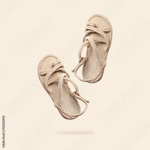 Summer female wicker sandals isolated on beige background. Fashionable trendy rope straw sandals. Jute slippers. Handmade Eco-friendly natural shoes. Cut out objects for design, Mock up photo