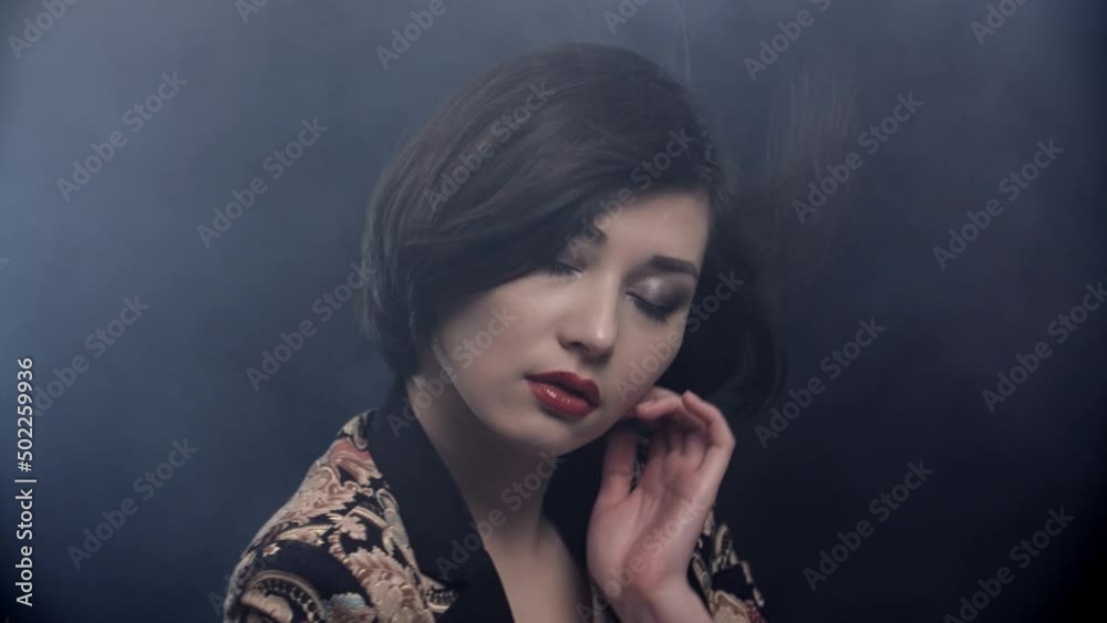 Stylish brunette asian girl dancing near wall with smoke lines light . Trendy young woman dancing single in club . Hot girl with long hair performs modern dance against concrete wall . Stylish brunette asian girl dancing near wall with smoke lines light . Trendy young woman dancing single in club . Hot girl with long hair performs modern dance against concrete wall .