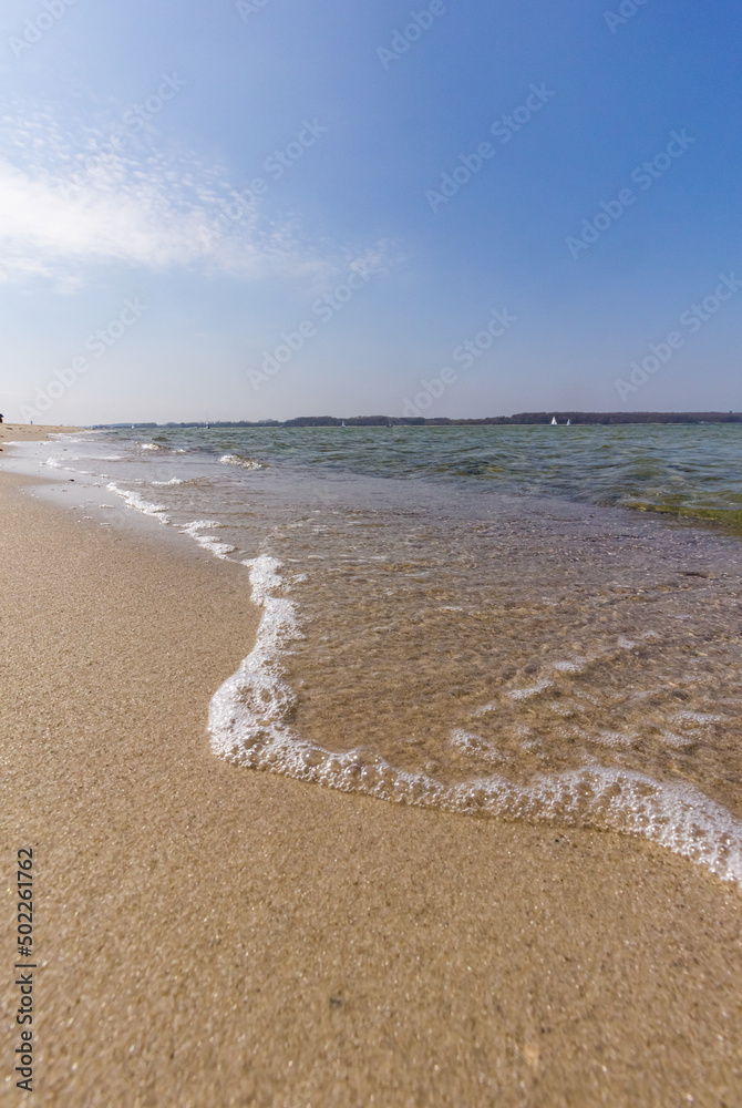 Foamy waves on a sandy beach in the early morning at the baltic sea Foamy waves on a sandy beach in the early morning at the baltic sea