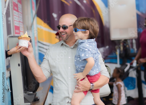Dad and son buying and eating ice-cream in boxi parkin lake nona florida 