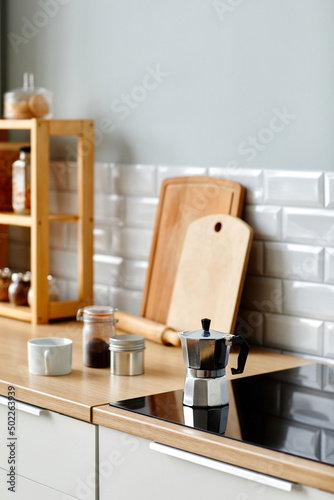 Vertical background image of ozy minimal kitchen with wooden decor elements and coffee pot on stove  copy space
