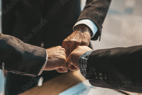 Three people put their fists together, businessmen joint venture start up companies, they are young entrepreneurs start up companies. up together to manage a plan to make the company profitable.