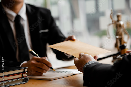 Attorneys are accepting documents from clients who come in to testify in case of embezzlement from business partners who venture into business. The concept of hiring a lawyer for legal proceedings. photo