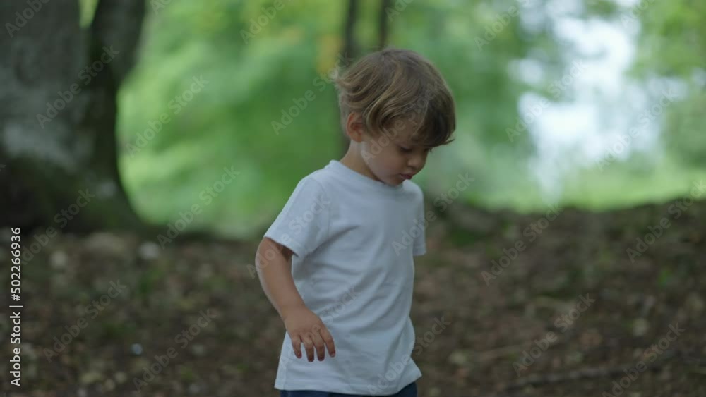 Child walking outside in nature little boy walks outdoors in green path Child walking outside in nature little boy walks outdoors in green path