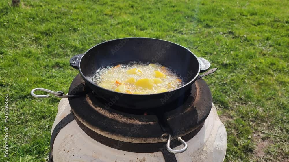 Cooking potatoes and carrots grilled in oil in pan. Street food. 27 April 2022, Minsk, Belarus Cooking potatoes and carrots grilled in oil in pan. Street food. 27 April 2022, Minsk, Belarus