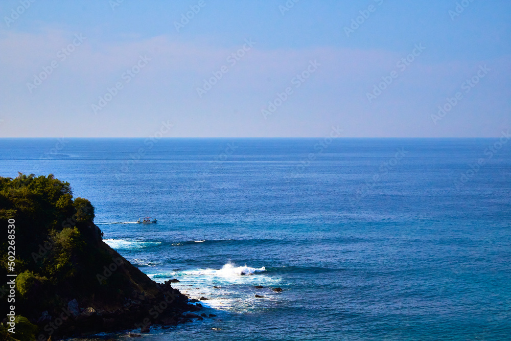 cliff in front of a sea with waves in beautiful day with blue sky in puerto escondido oaxaca 