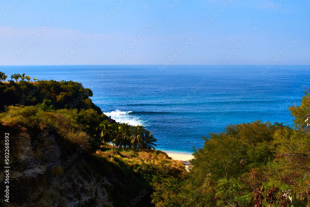 cliff in front of the beach with blue sean in sunny day in puerto escondido oaxaca 