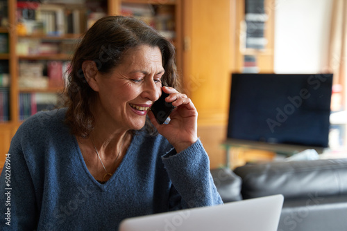 Photography Technlogy savvy senior entrepreneur woman with smartphone and laptop