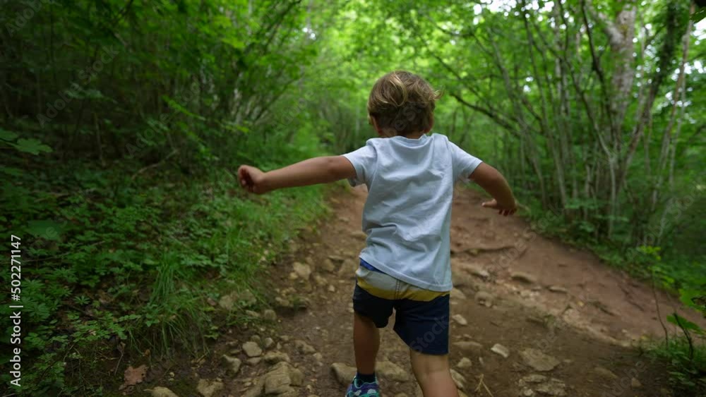 Child playing in nature running in woods path Child playing in nature running in woods path