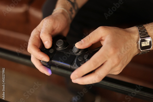 Playing games concept. Part body man with joystick play game on console. Male hands holding pad. High quality photo