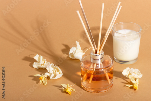 reed diffuser with flowers. Incense sticks for the home with a floral scent with hard shadows. The concept of eco-friendly fragrance for the home