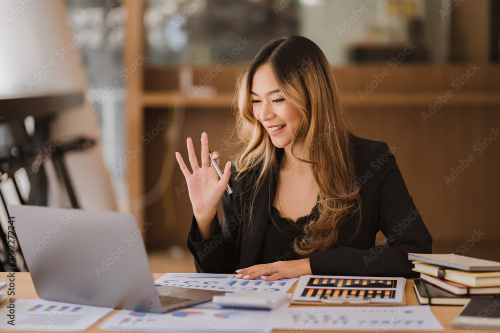 Fototapeta premium Asian businesswoman in formal suit in office happy and cheerful during using smartphone and working