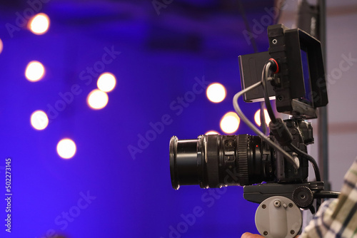 camera on a tripod against a blue backlight