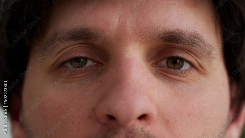 A close-up of an attractive man opens his beautiful brown eyes. Caucasian young male model looking into the camera A close-up of an attractive man opens his beautiful brown eyes. Caucasian young male model looking into the camera