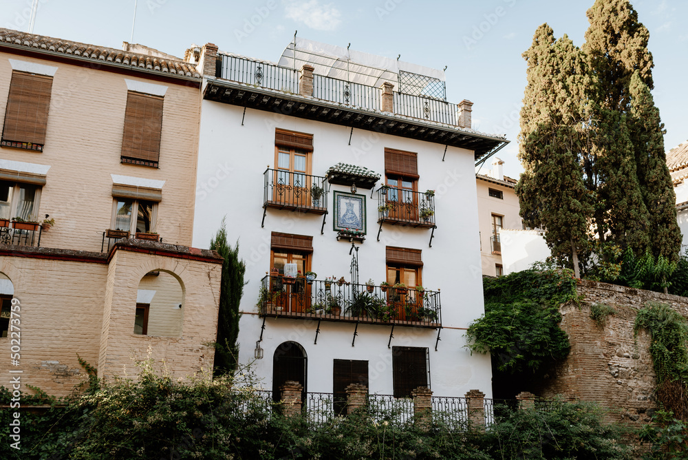 Facade of a house in the Albaicín neighborhood, Granada, with a typical Andalusian balcony full of flowers.