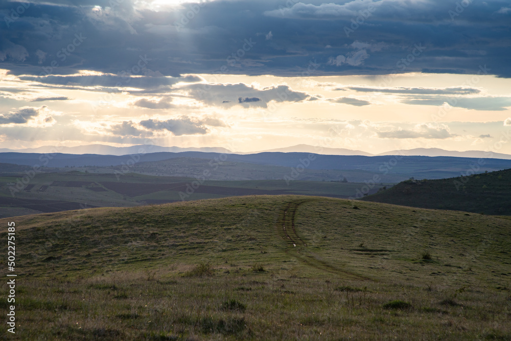 Fototapeta premium amazing sunset sky over green hills in early summer