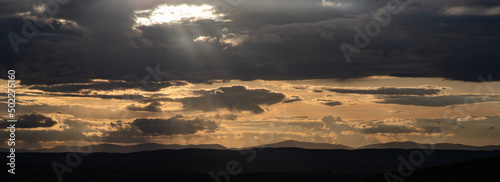 amazing sunset sky over green hills in early summer