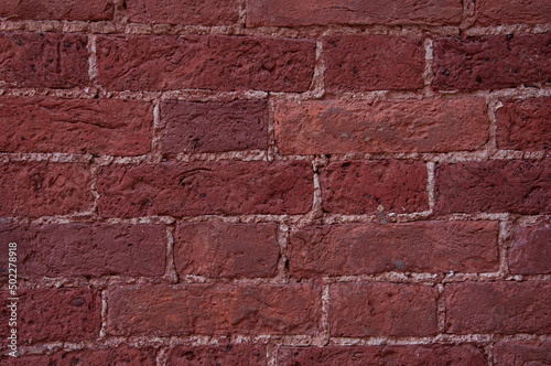 Texture of the wall of a building made of ancient red-brown brick close-up