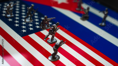 Photography The concept of the economic and political crisis between the United States and Cuba, toy soldiers attacking each other against the background of national flags