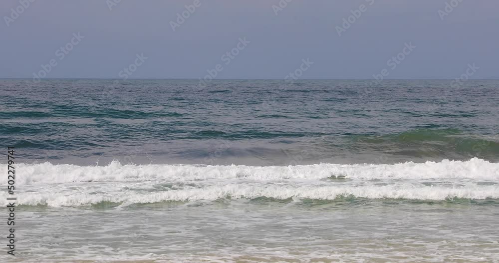 The waves of the sea break on the shoreline of the beach. The waves of the sea break on the shoreline of the beach.
