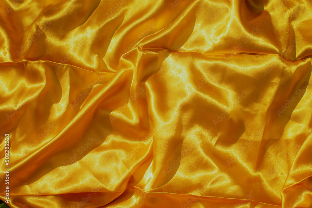 Natural silk background. Yellow fabrics or tissue Natural silk background. Yellow fabrics or tissue