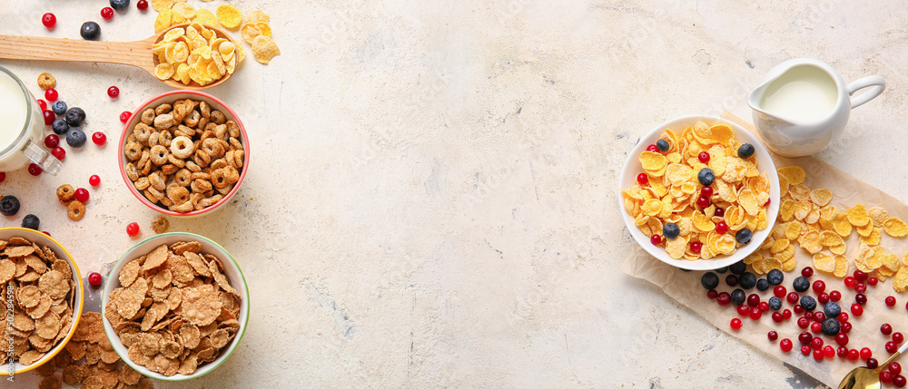 Different breakfast cereals, milk and berries on light background with space for text Different breakfast cereals, milk and berries on light background with space for text