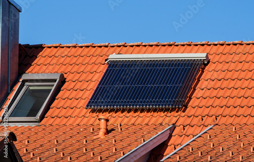 Solar water panel heating on a red roof