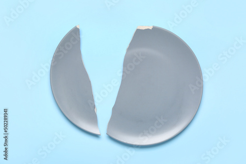 Broken ceramic plate on blue background