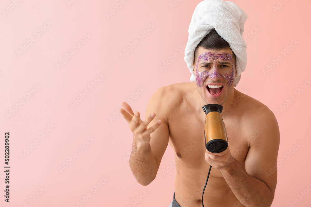 Handsome man with glitter mask and blow dryer singing on pink background Handsome man with glitter mask and blow dryer singing on pink background