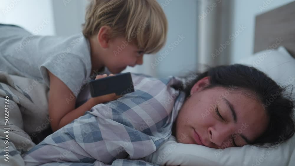 child waking up mother in morning bed jumping on top mom child waking up mother in morning bed jumping on top mom