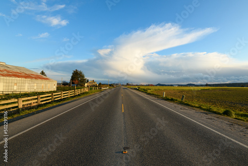 Rural road passing through the Skagit Valley of Washington State with a Spring storm on the horizon photo