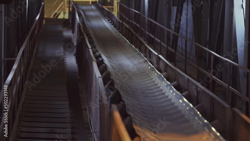 Conveyor belt in a factory of building materials production. Stock footage. Close up of production line with small crushed stones or gravel.