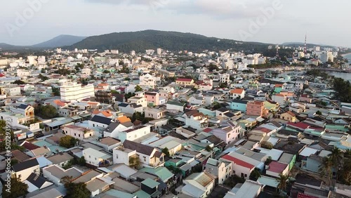 Aerial View of a small Resort Town with Residential Buildings and Hotels with a Swimming Pool and Palm Trees, Near the Ocean and Sand photo