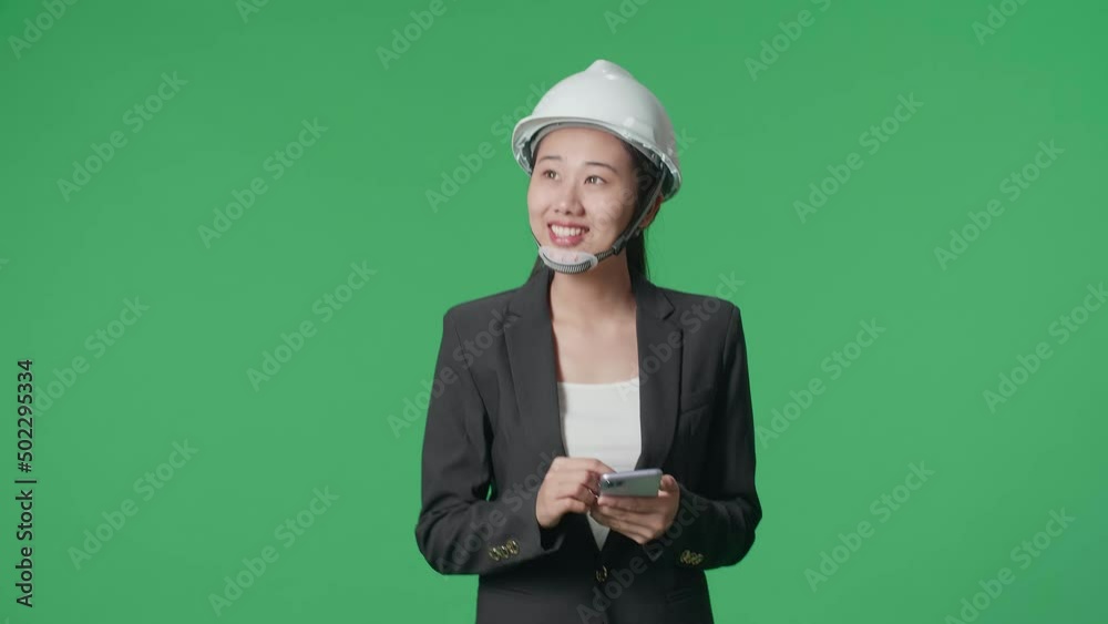 Smiling Asian Female Engineer Using Smartphone And Looking Around While Walking In The Green Screen Studio
Smiling Asian Female Engineer Using Smartphone And Looking Around While Walking In The Green Screen Studio