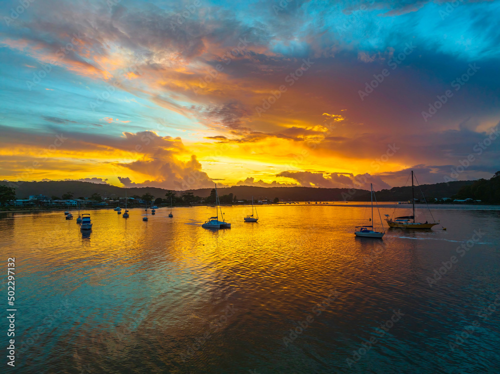 Aerial sunrise waterscape with boats, colour and clouds