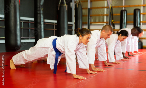 Training a group of athletes before karate training - push-ups and muscle warm-up