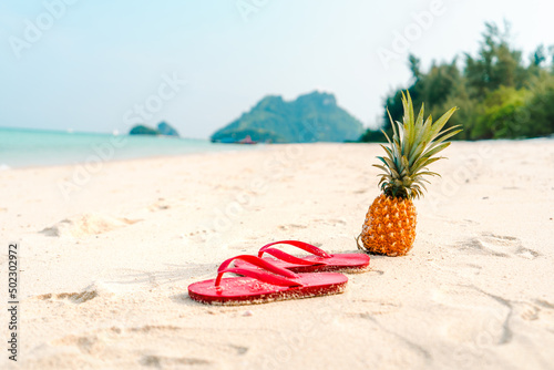Summer beach vacation with pineapples and flip flops on the beach