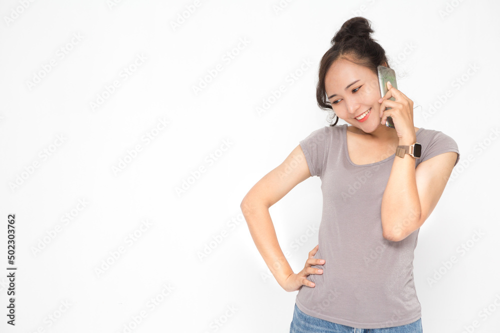 Beautiful Asian woman wearing grey casual shirt holding smartphone on white background and copy space. Cute Asian woman smiling and cheerful talk something on the phone for social media concept Beautiful Asian woman wearing grey casual shirt holding smartphone on white background and copy space. Cute Asian woman smiling and cheerful talk something on the phone for social media concept