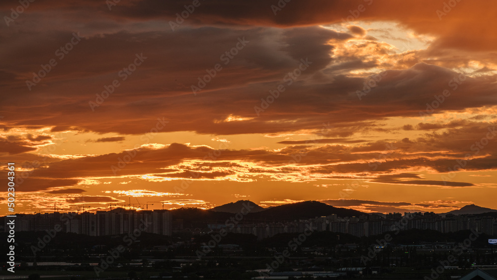 Obraz premium The cityscape under the cloudy sunset