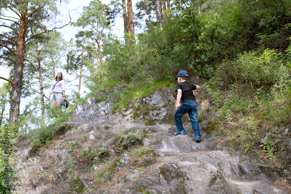 Little boy walking with parent in the mountains