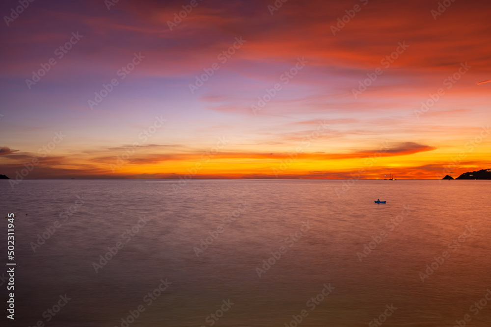 Landscape Long exposure of majestic clouds in the sky sunset or sunrise over sea with reflection in the tropical sea Beautiful seascape scenery Amazing light of nature sunset
