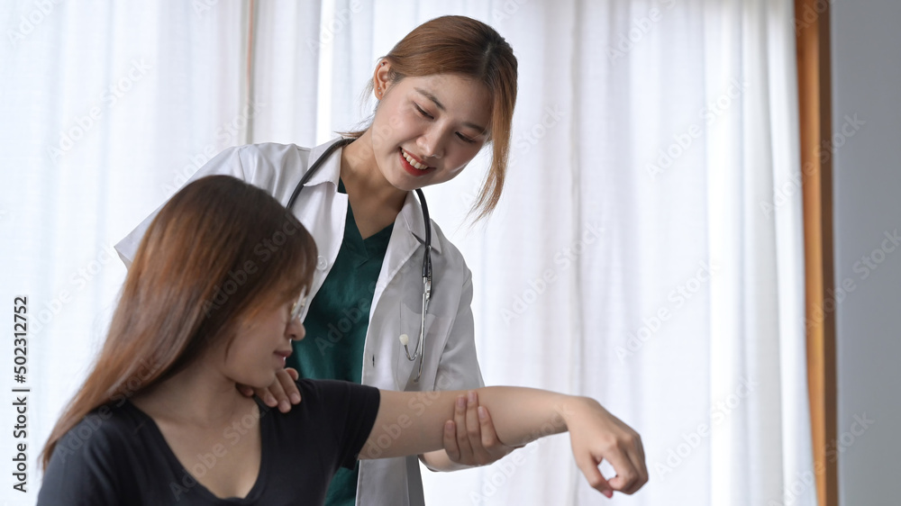 Fototapeta premium Smiling female physiotherapist working with patient in clinic. Physical therapy concept.