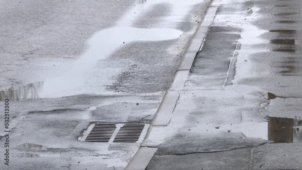 Rain flowing into a stormwater sewer system. Stormwater street drain during heavy rain. a sewer grate in the street