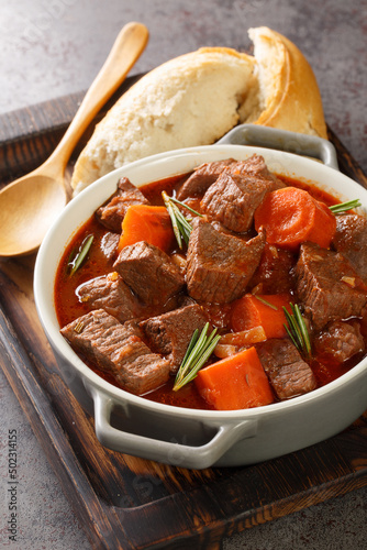 Daube Provencal French braised beef red wine, and vegetable stew closeup in the wooden tray on the table. Vertical