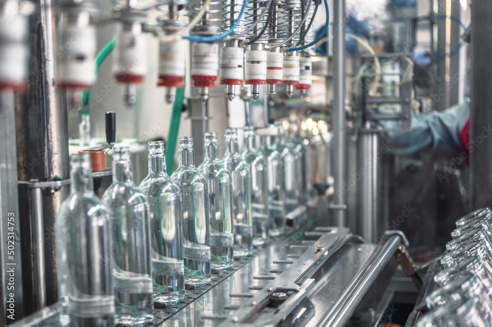 Equipment pours vodka into glass bottles on production line Equipment pours vodka into glass bottles on production line