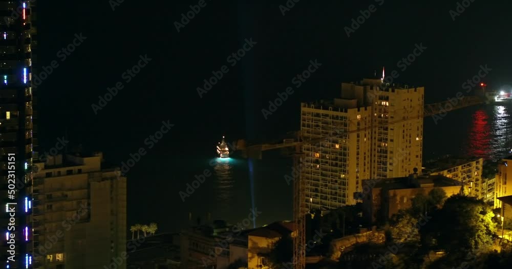 Aerial Shot Of Tall Illuminated Buildings By Sea In City At Night - Monaco Aerial Shot Of Tall Illuminated Buildings By Sea In City At Night - Monaco