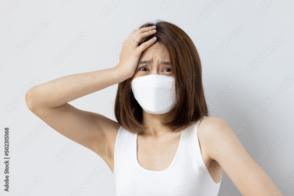Frustrated woman still wearing mask and having headache fever or long covid symptom