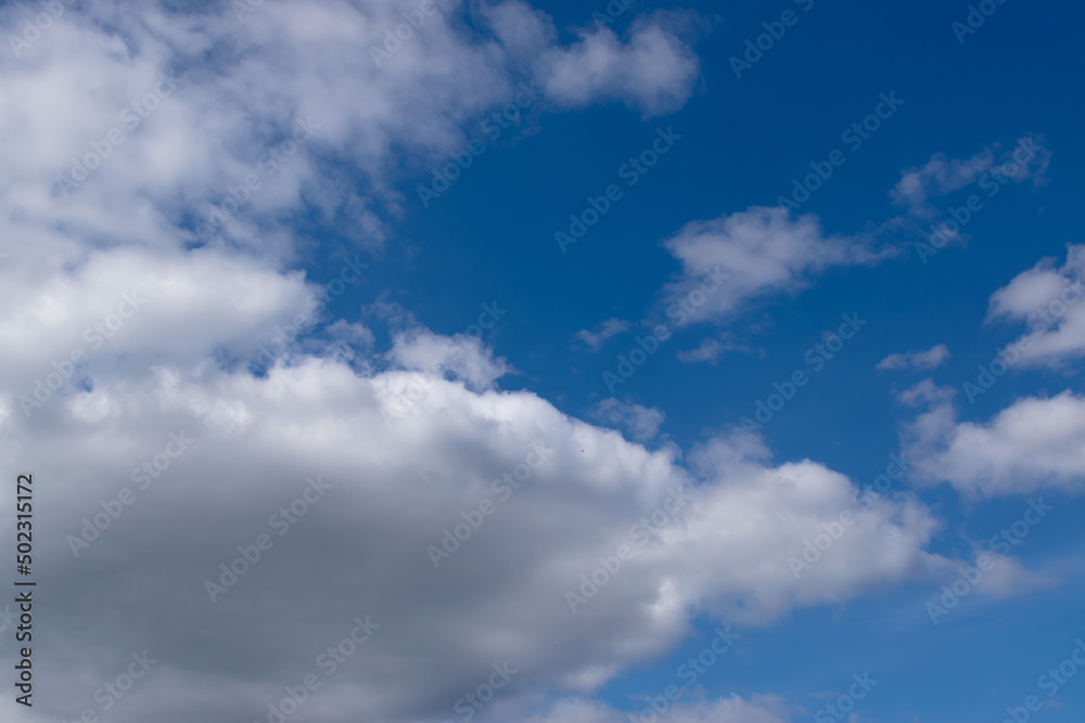 Fluffy white clouds on a blue sky background. Nature background