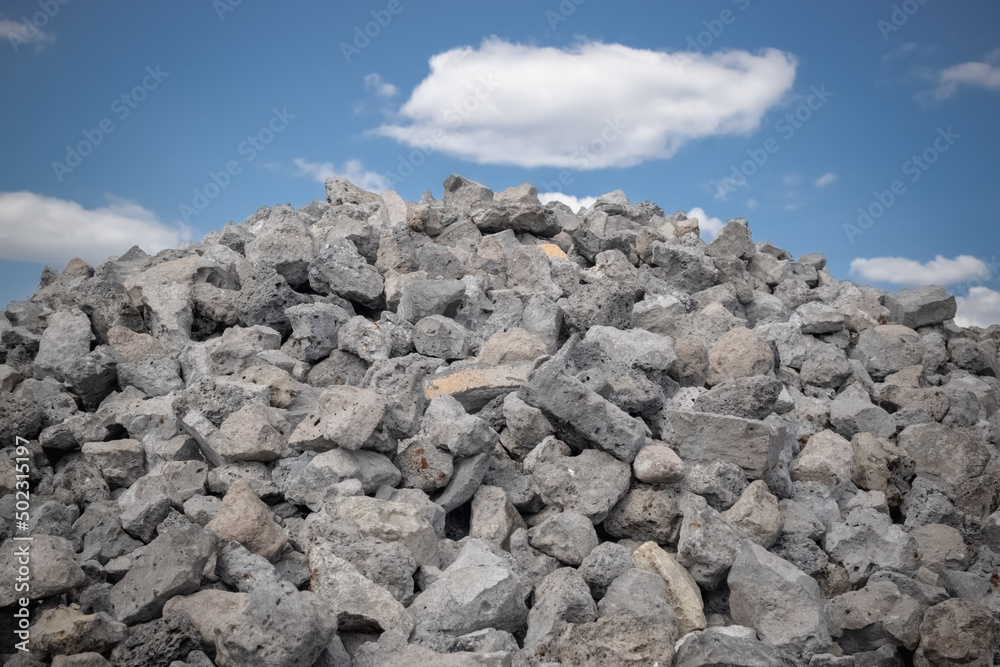 Close-ups of crushed stone for construction and road works against the blue sky