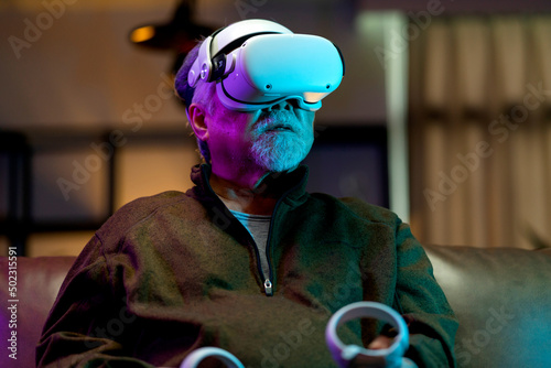 exicet asian senior old man white beard enjoy virtual augmented reality metaverse esport online digital world game in living room at home,casial relax old man play digital leisure game at home